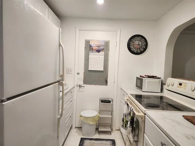 a kitchen with refrigerator and cabinets