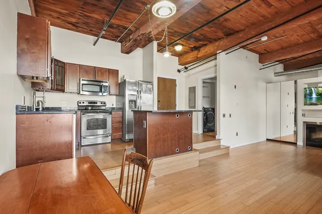 a kitchen with stainless steel appliances granite countertop a refrigerator a stove top oven a sink and dishwasher