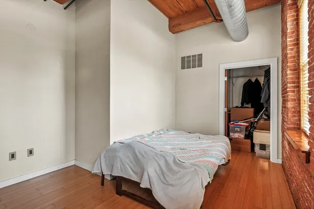 a bedroom with a bed and wooden floor