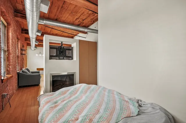 a bedroom with a bed and wooden floor