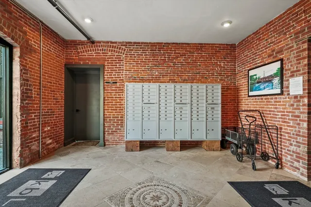 a view of a street with brick wall and fence