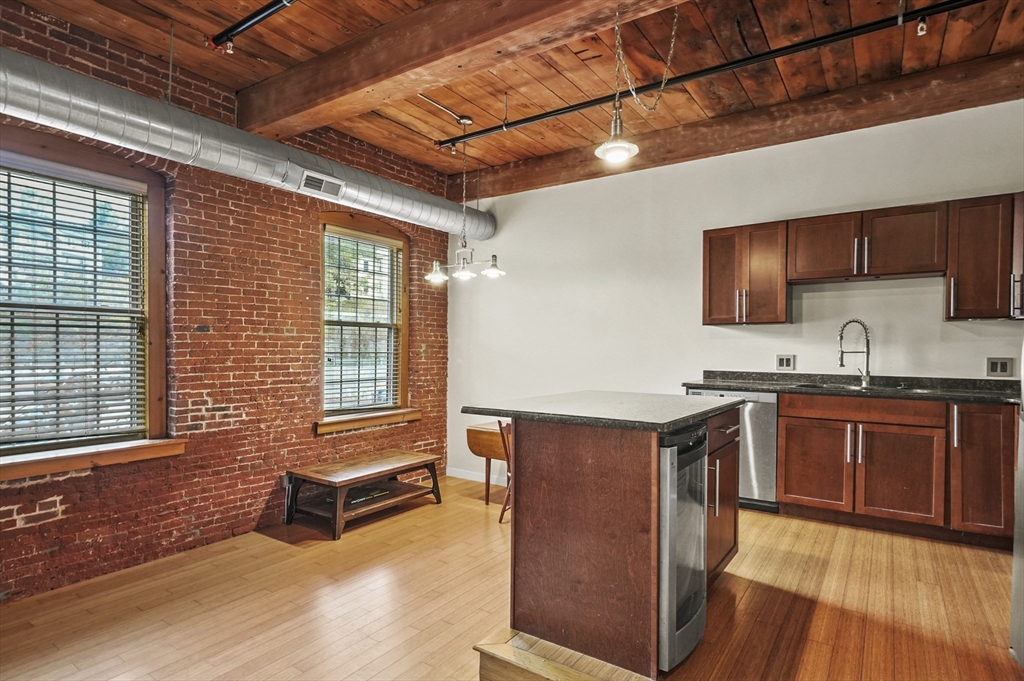 1511 Main Street, Unit C405 Worcester, MA 01603 - Photo 10 of 23 a kitchen with stainless steel appliances granite countertop a stove a sink and a microwave