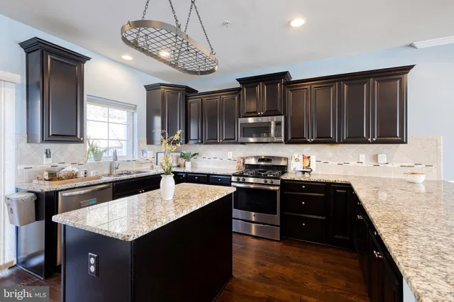 a kitchen with granite countertop stainless steel appliances and wooden cabinets