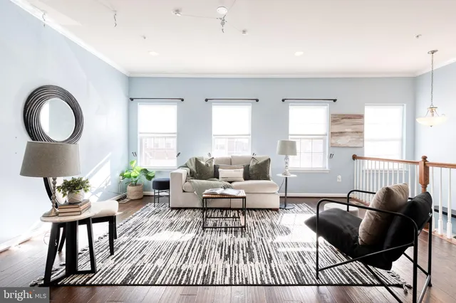a living room with furniture and a wooden floor