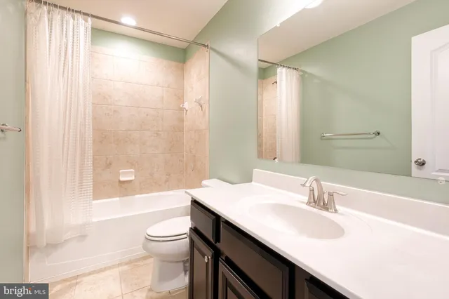 a bathroom with a granite countertop sink toilet a large mirror and shower