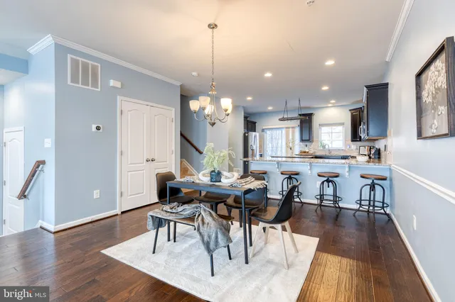 a view of a dining room and livingroom with furniture wooden floor a chandelier