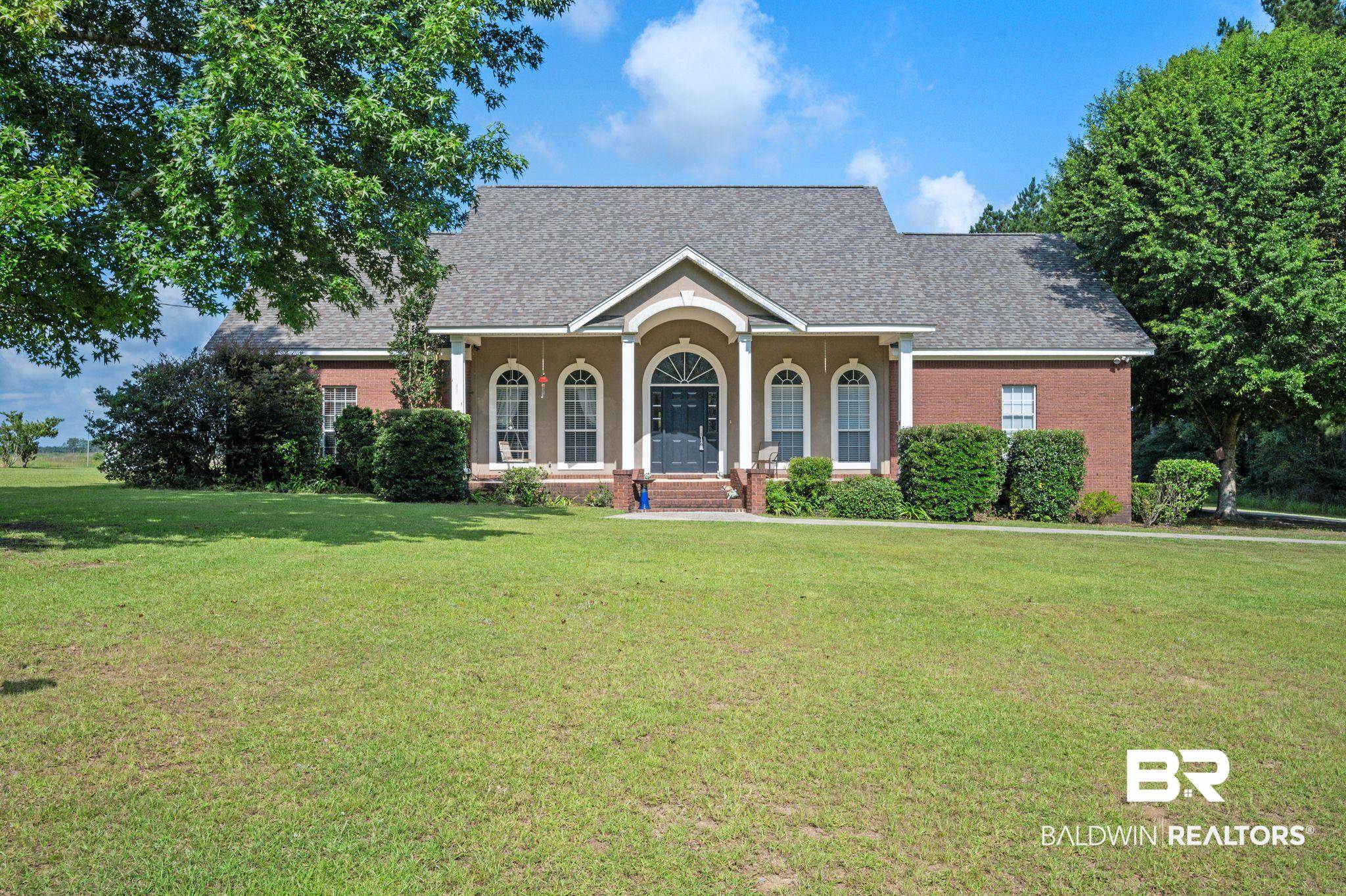 48513 Phillipsville Road Bay Minette, AL 36507 - Photo 1 of 50 View of front facade featuring a front yard, brick siding, roof with shingles, and a porch