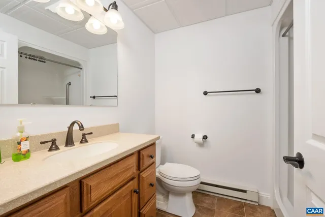 a bathroom with a sink a toilet and a mirror
