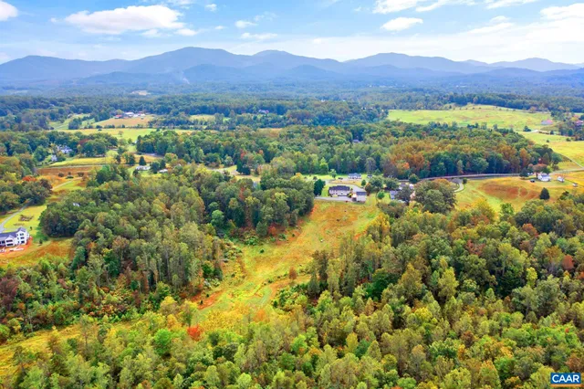 an aerial view of a houses with a lush green hillside