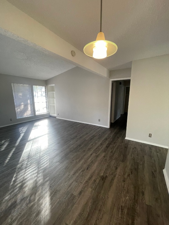 12613 Tree Line Drive, Unit A Austin, TX 78729 - Photo 13 of 15 a view of an empty room with window and wooden floor