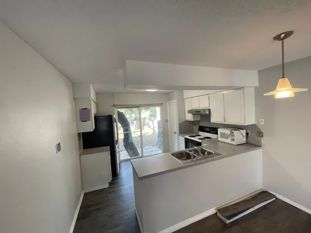 a kitchen with stainless steel appliances granite countertop a sink a stove and a refrigerator