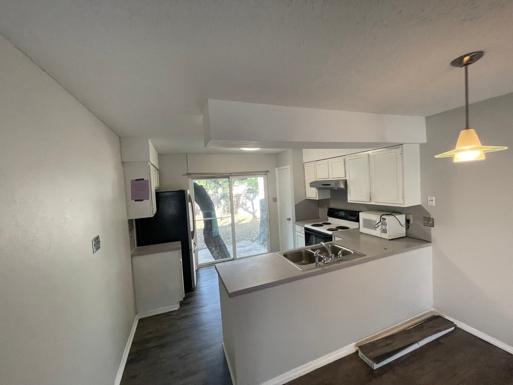 12613 Tree Line Drive, Unit A Austin, TX 78729 - Photo 3 of 15 a kitchen with stainless steel appliances granite countertop a sink a stove and a refrigerator