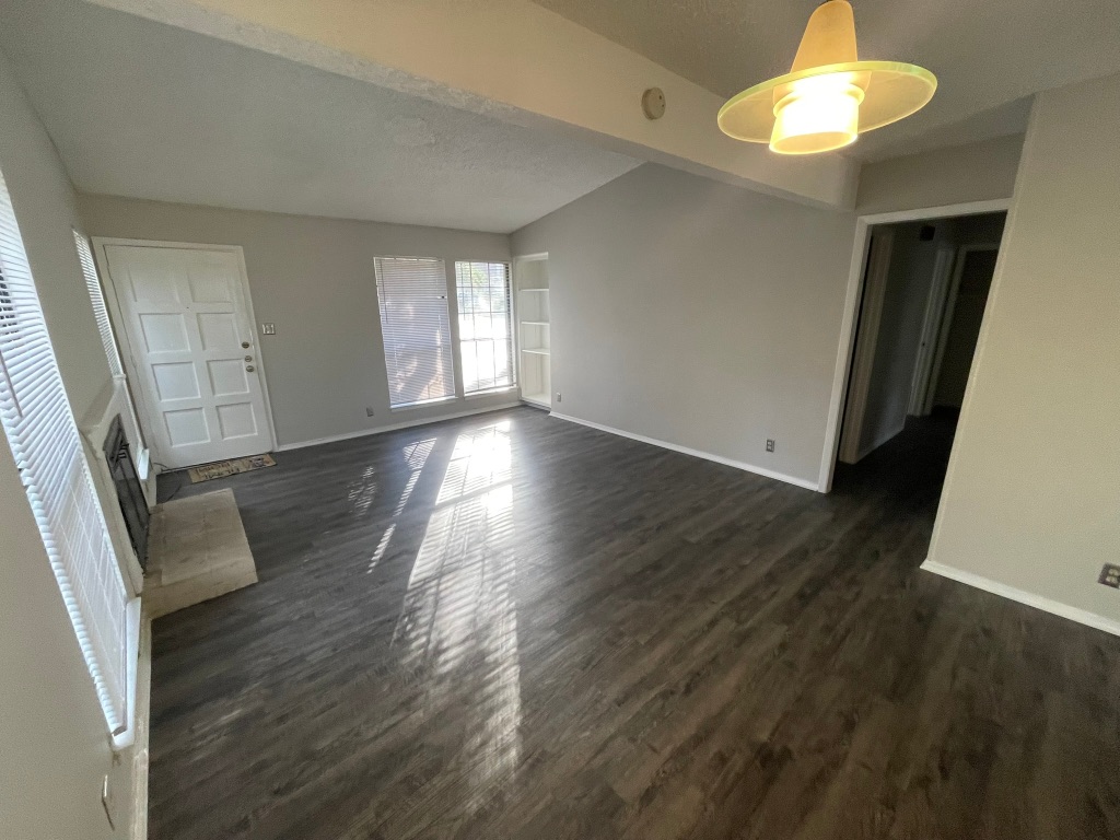 12613 Tree Line Drive, Unit A Austin, TX 78729 - Photo 5 of 15 an empty room with wooden floor and windows
