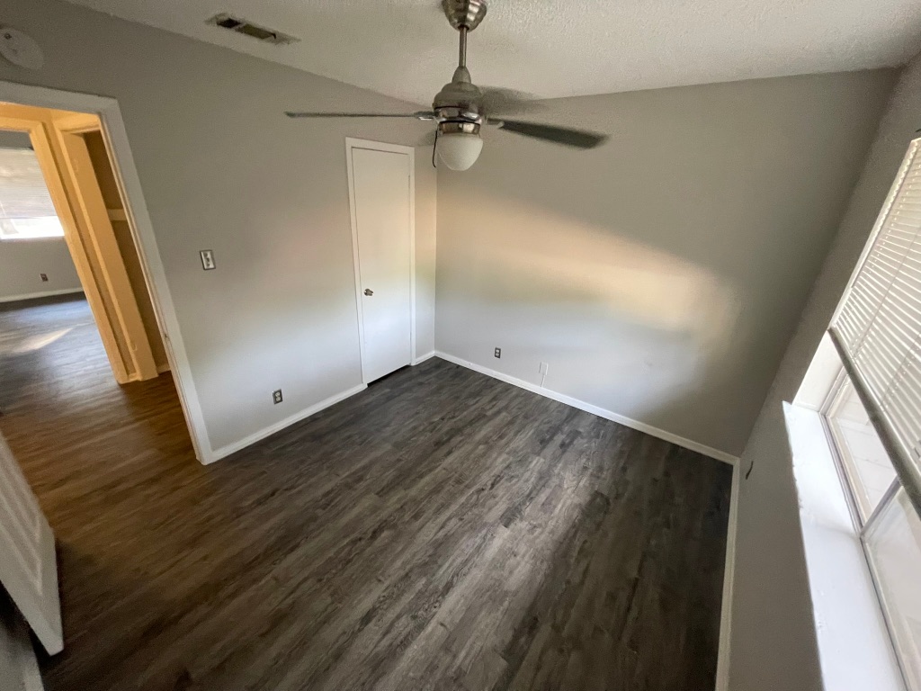 12613 Tree Line Drive, Unit A Austin, TX 78729 - Photo 7 of 15 a view of a room with wooden floor and windows