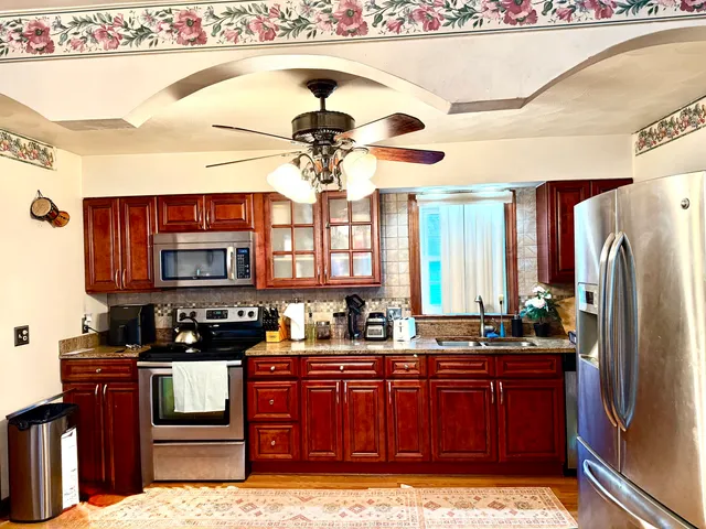 a kitchen with stainless steel appliances granite countertop a stove a sink and a refrigerator