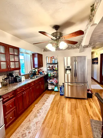 a kitchen with stainless steel appliances kitchen island granite countertop a stove and cabinets