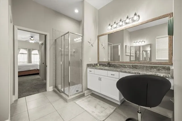 a bathroom with a granite countertop sink a mirror and a bathtub