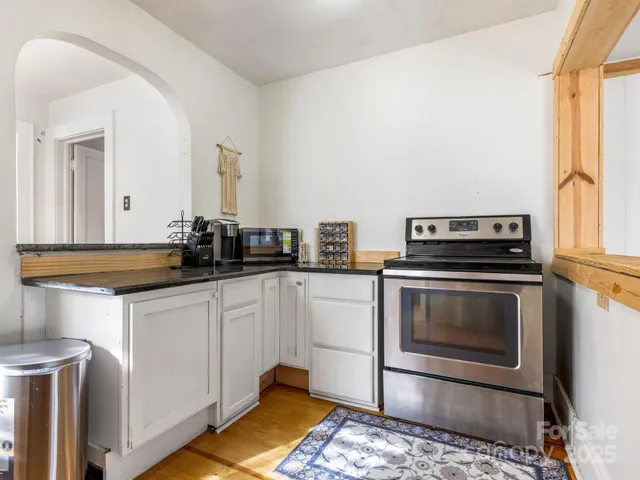 a kitchen with a stove and white cabinets