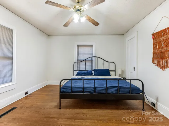 a bedroom with a bed window and a chandelier