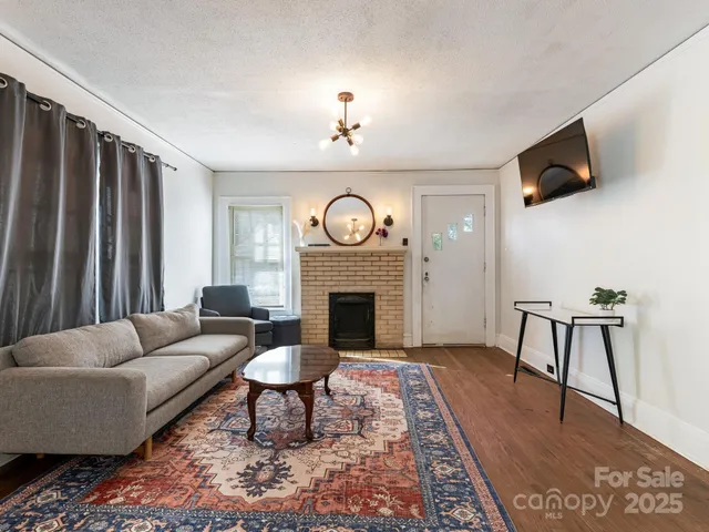a living room with furniture a fireplace and a flat screen tv