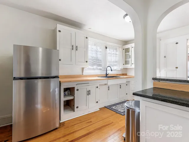 a kitchen with a refrigerator sink and cabinets
