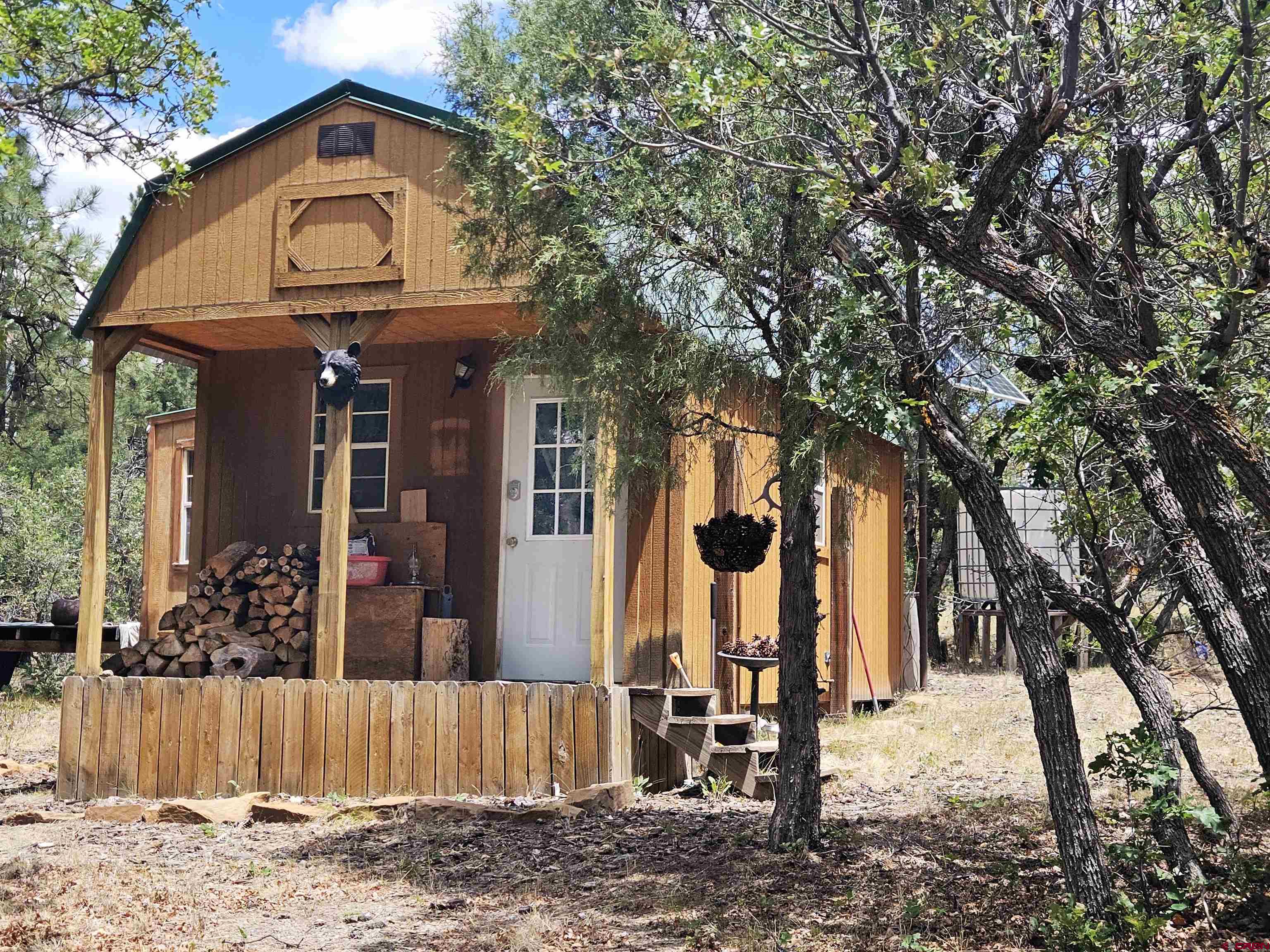 543 Justin's Road Pagosa Springs, CO 81147 - Photo 1 of 41 a view of a house with a tree and wooden fence