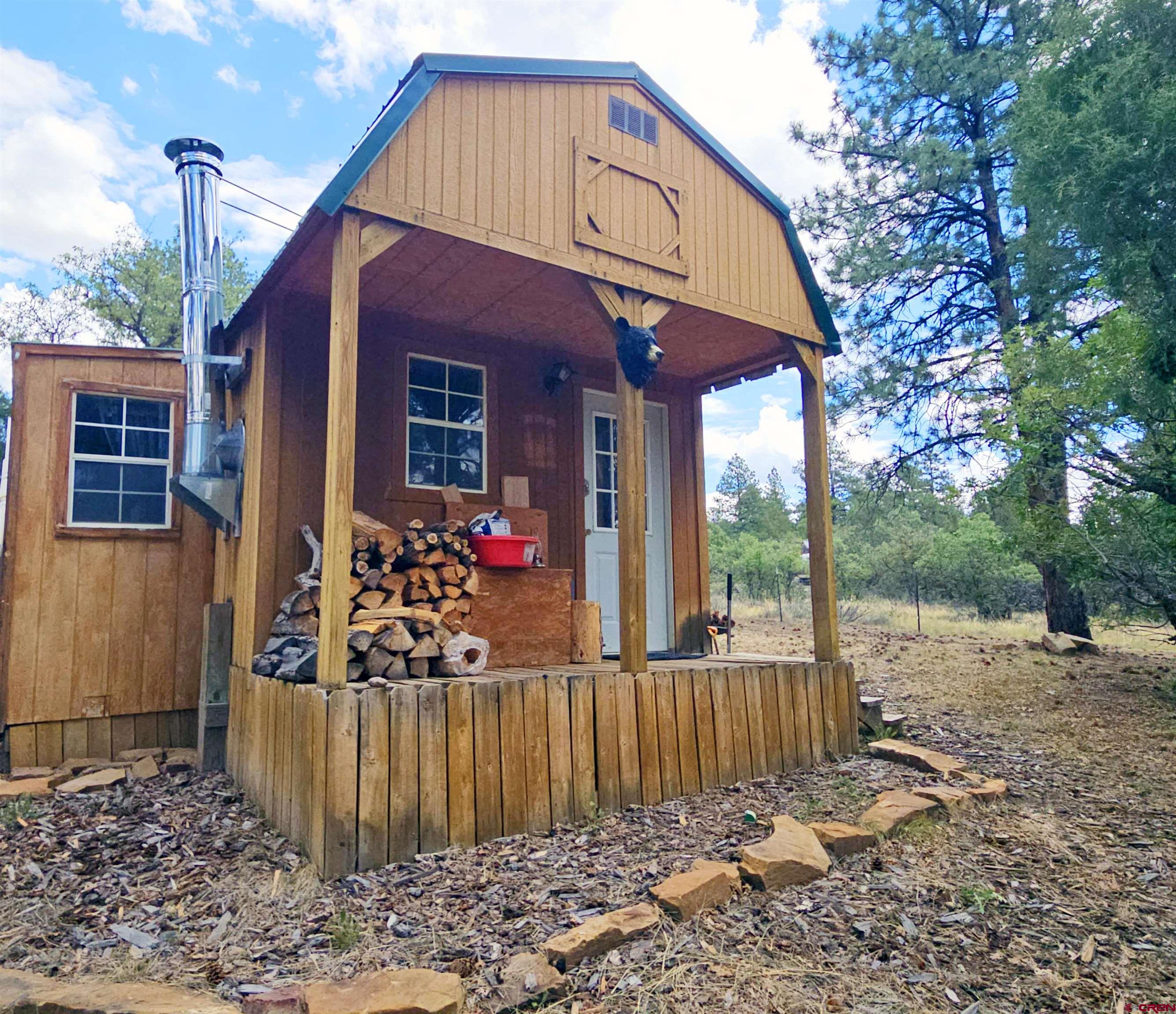 543 Justin's Road Pagosa Springs, CO 81147 - Photo 32 of 41 a view of a house with a small yard and floor to ceiling window