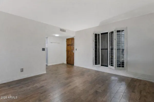 an empty room with wooden floor and door