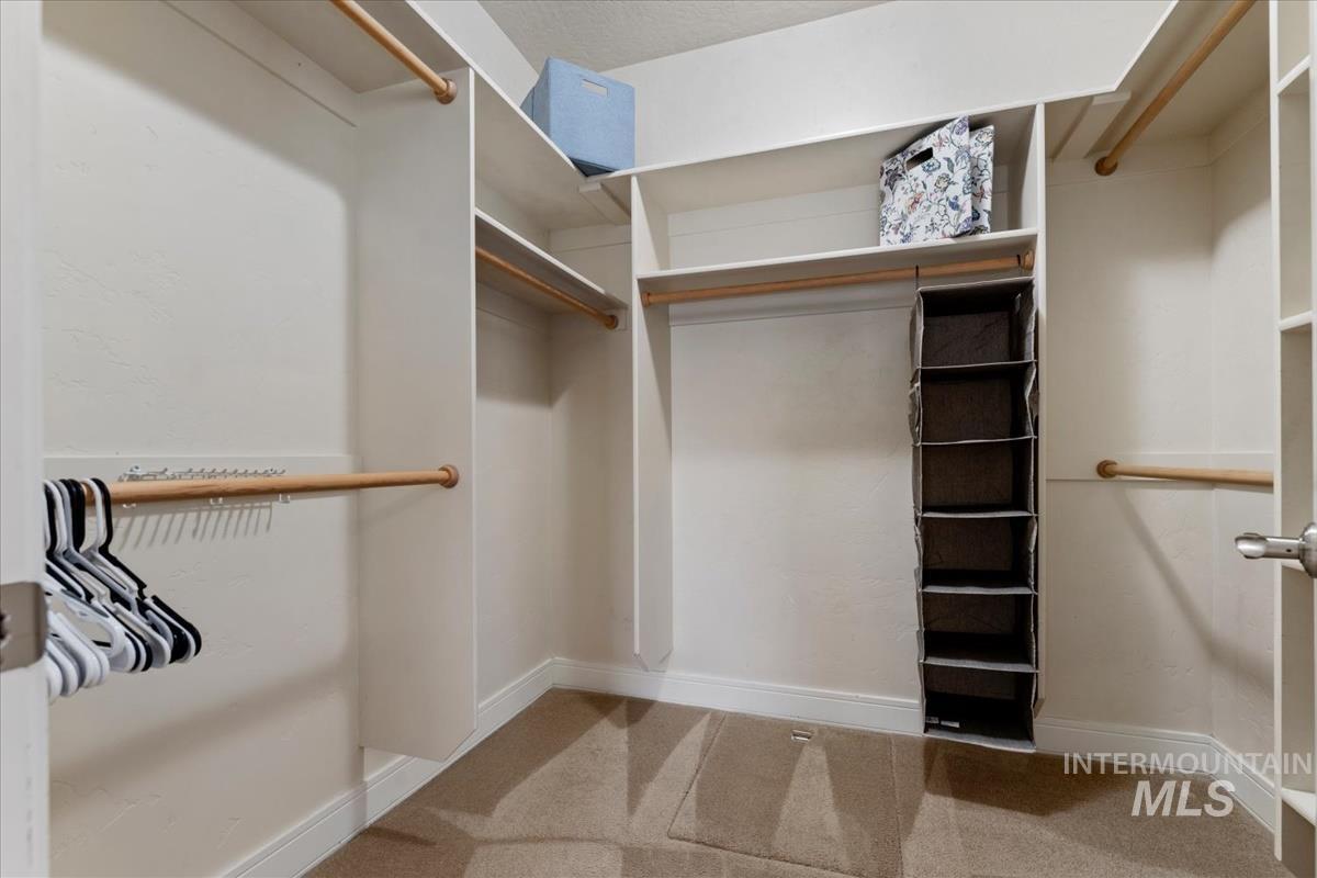 640 Southwest Miner Street Mountain Home, ID 83647 - Photo 20 of 35 Walk-in closet featuring white built-in shelving, multiple hanging rods, and carpet flooring