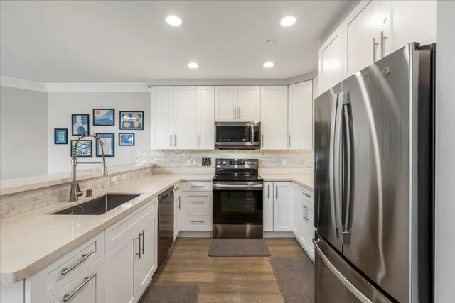 a kitchen with stainless steel appliances a refrigerator and a stove top oven