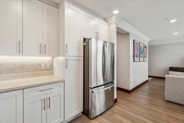 a kitchen with white cabinets and black appliances