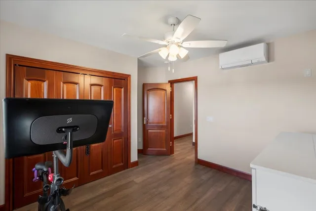 a room with chandelier fan and wooden floor
