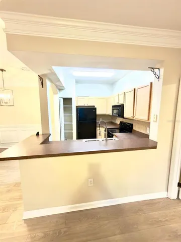 a living room with stainless steel appliances kitchen island granite countertop furniture and a fireplace