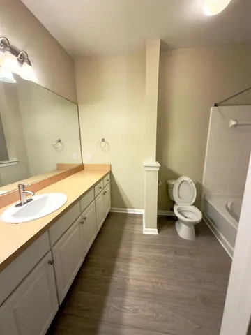 a bathroom with a double vanity sink toilet and a tub