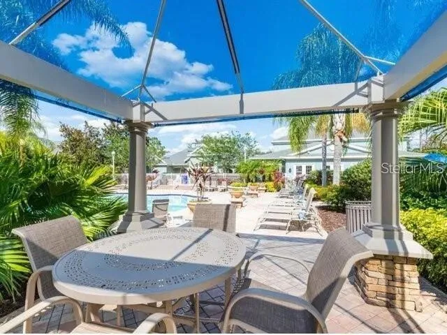 a view of a patio with a table chairs and a small yard