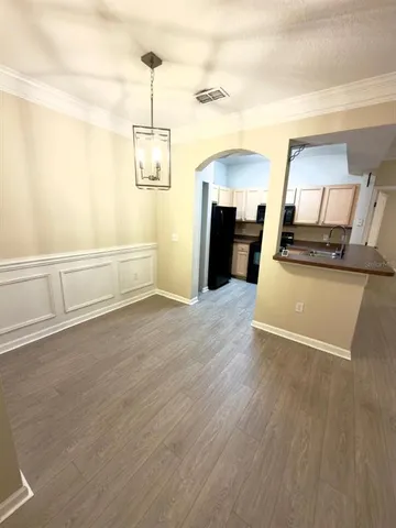 a view of a kitchen with wooden floor and electronic appliances