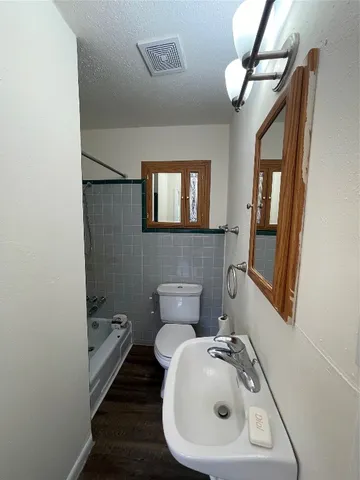 a bathroom with a sink mirror and toilet