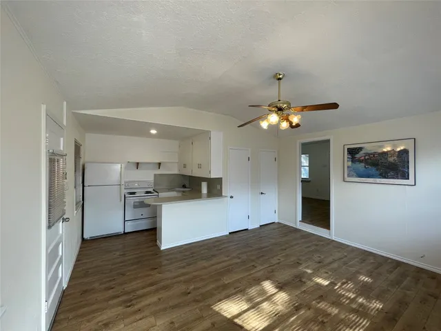 a kitchen with a refrigerator and ceiling fan
