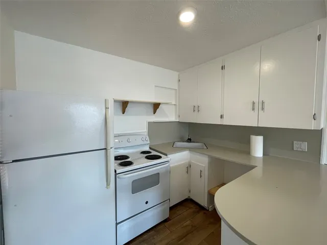 a kitchen with a white stove top oven and cabinets