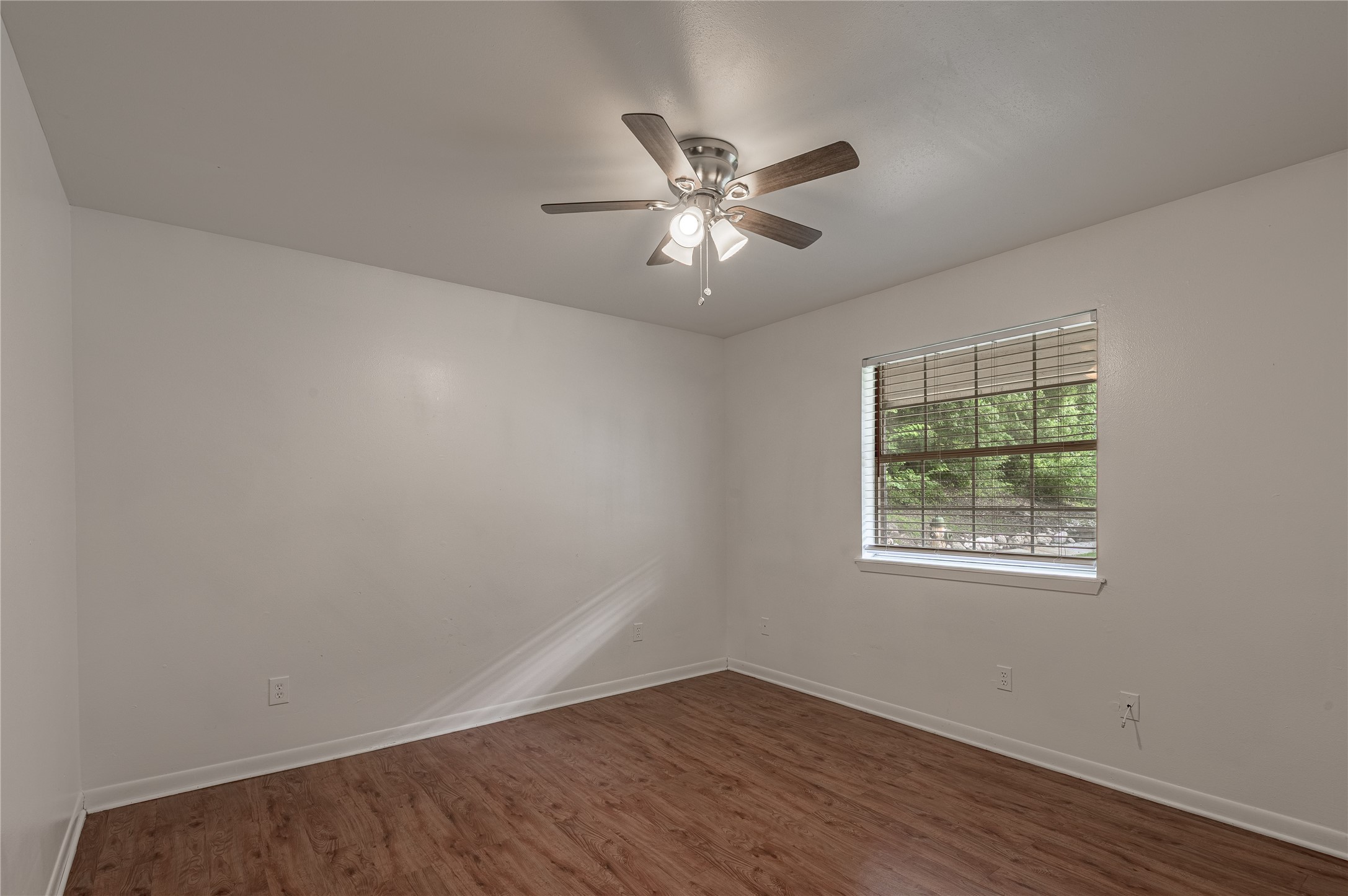 600 Palm Street, Unit 12 Huntsville, TX 77340 - Photo 12 of 23 a view of an empty room with wooden floor and a window