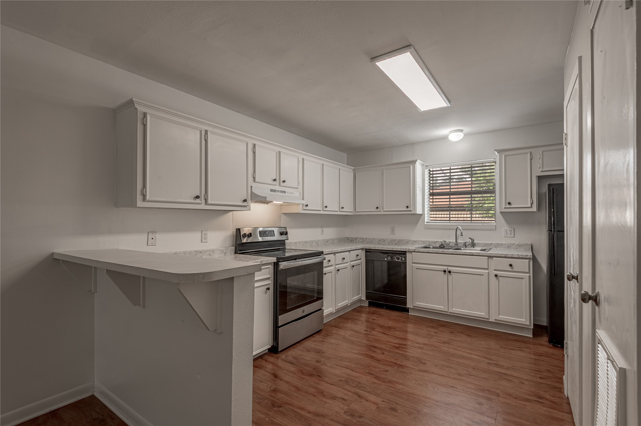 600 Palm Street, Unit 12 Huntsville, TX 77340 - Photo 8 of 23 a kitchen with stainless steel appliances granite countertop a stove a sink dishwasher and a refrigerator