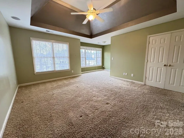 en empty room with windows and ceiling fan