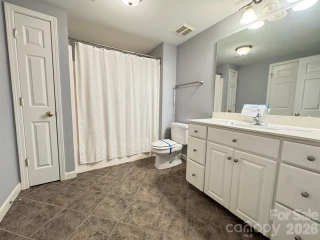 a spacious bathroom with a double vanity sink mirror and toilet