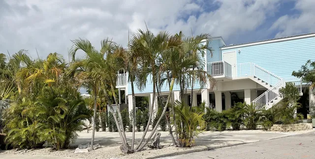 a front view of a house with a tree