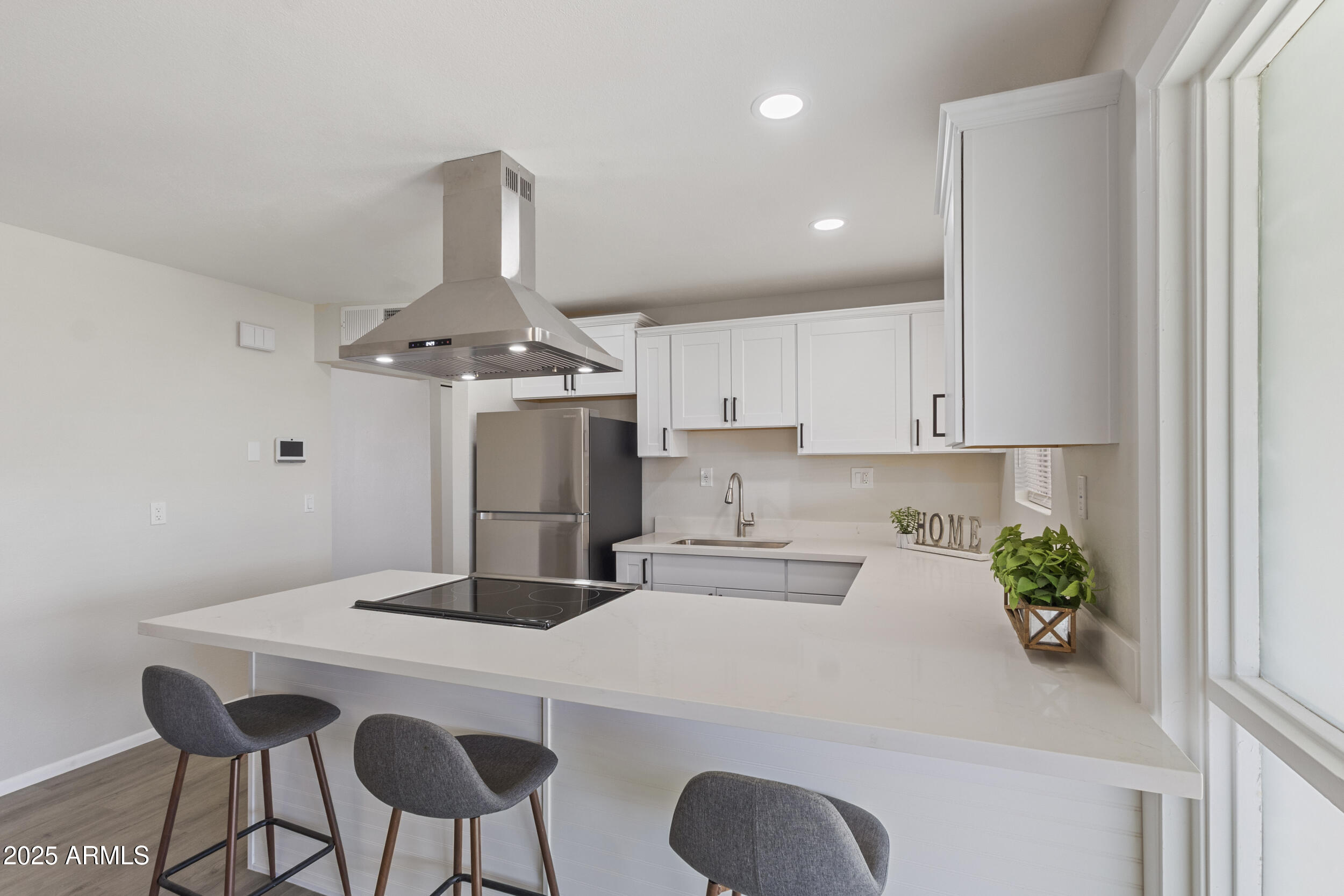 3339 West Shaw Butte Drive Phoenix, AZ 85029 - Photo 6 of 16 a kitchen with stainless steel appliances kitchen island granite countertop a dining table chairs and white cabinets