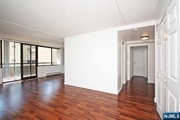 a view of an empty room with wooden floor