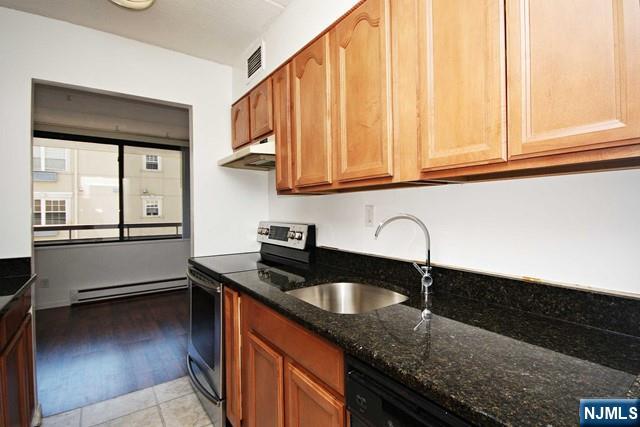 555 Gorge Road, Unit 3B Cliffside Park, NJ 07010 - Photo 5 of 11 a kitchen with granite countertop a sink a stove and cabinets