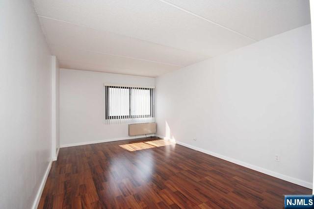 555 Gorge Road, Unit 3B Cliffside Park, NJ 07010 - Photo 10 of 14 an empty room with wooden floor and windows