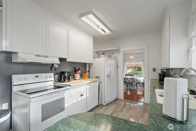 a kitchen with white cabinets and white appliances