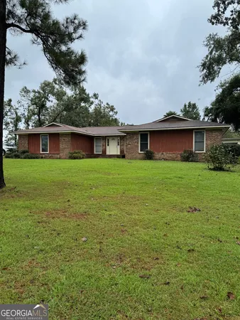 a view of a house with a yard and sitting area